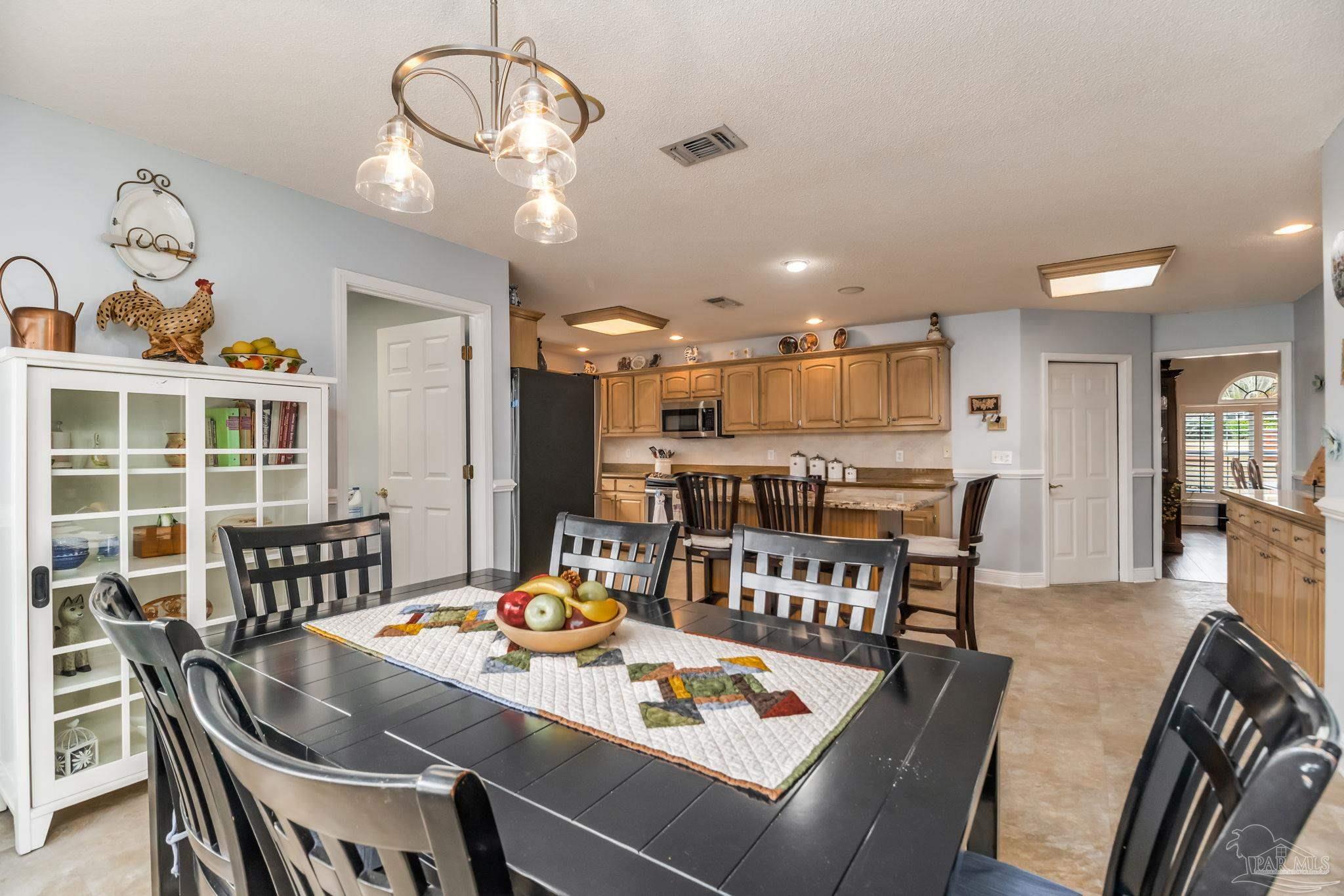 3106 Cobblestone Drive Pace, FL 32571 - Photo 19 of 61 a dining room with furniture a window and wooden floor