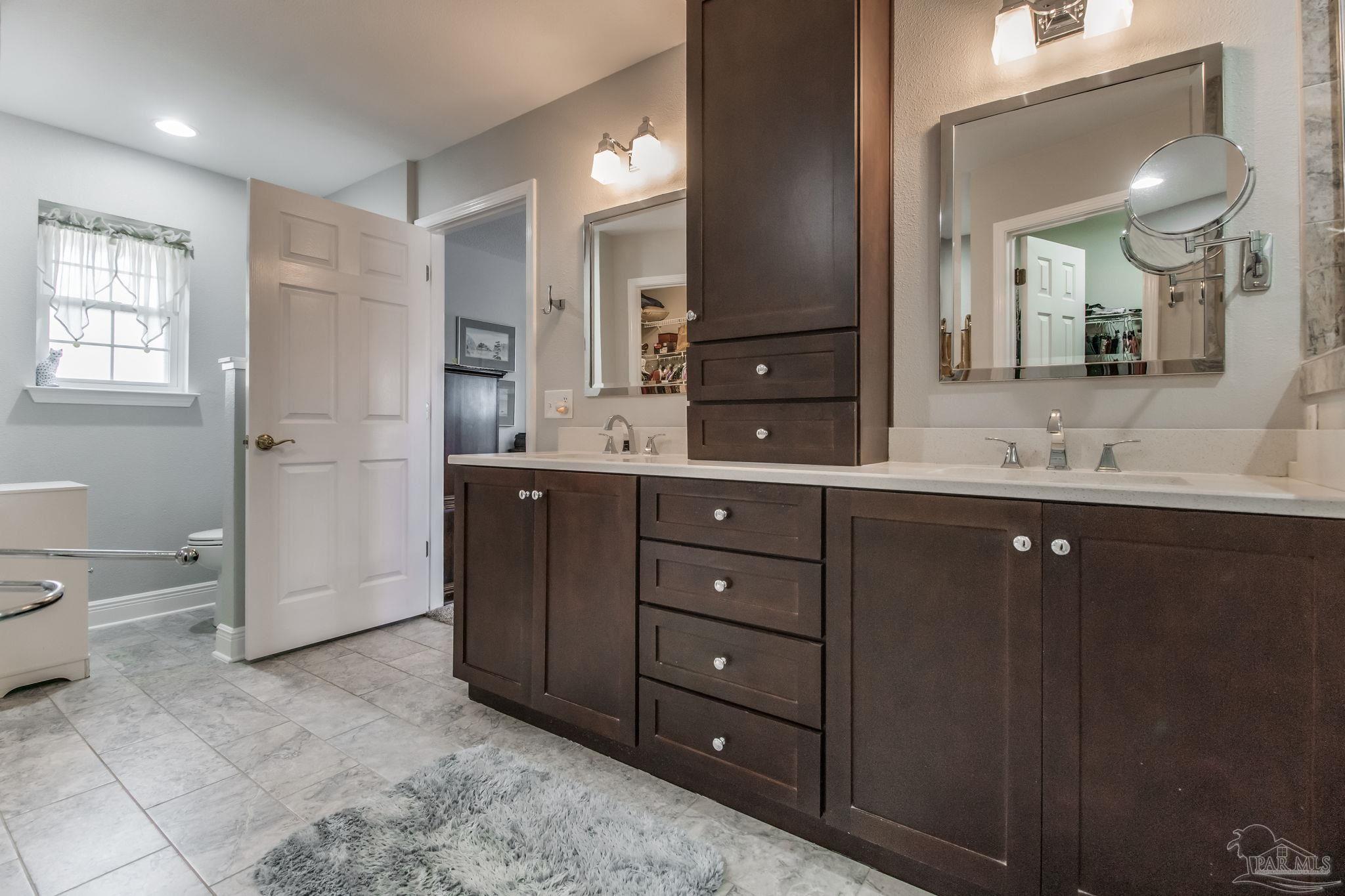 3106 Cobblestone Drive Pace, FL 32571 - Photo 28 of 61 a spacious bathroom with a double vanity sink toilet mirror and bathtub