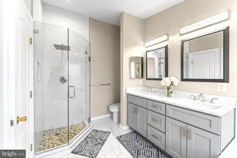 a spacious bathroom with a double vanity sink mirror and toilet