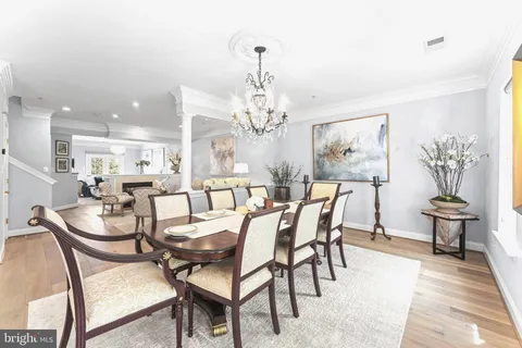 a dining room with furniture a chandelier and wooden floor