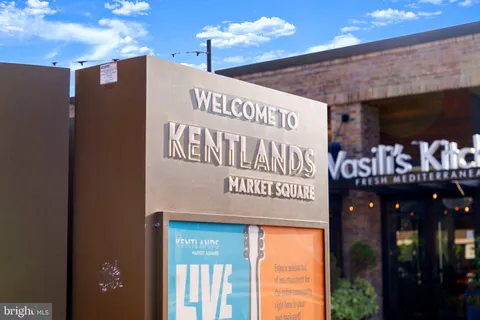 a view of a patio with a table and chairs under an umbrella with a barbeque
