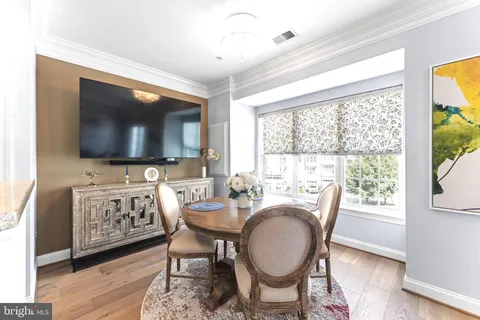 a dining room with furniture a flat screen tv and a floor to ceiling window