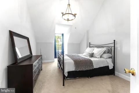 a spacious bedroom with a bed a window and dresser