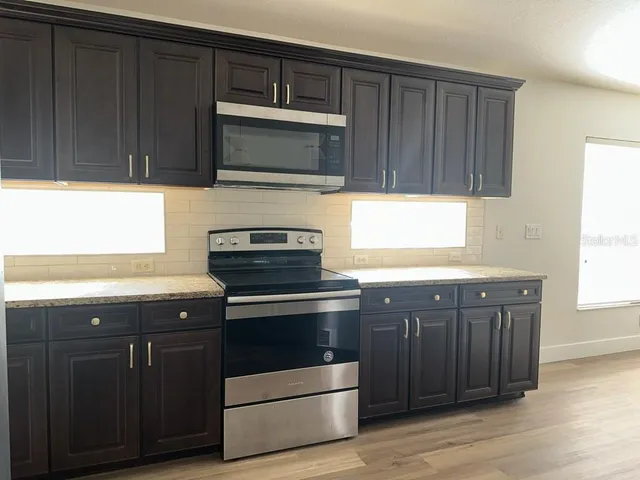 a kitchen with wooden cabinets and stainless steel appliances