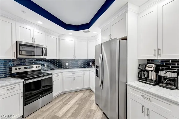 a kitchen with granite countertop a refrigerator stove and microwave