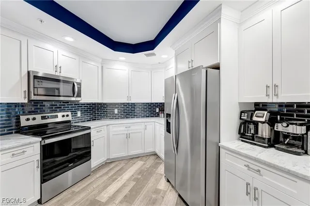 a kitchen with granite countertop a refrigerator stove and microwave