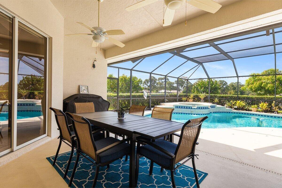 212 Southwest Whitewood Drive Port St. Lucie, FL 34953 - Photo 13 of 26 a view of a patio with a table and chairs under an umbrella