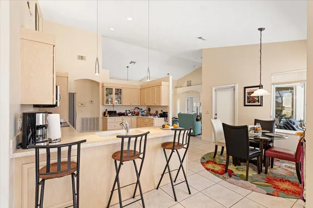 a view of a dining room and livingroom with furniture wooden floor a chandelier