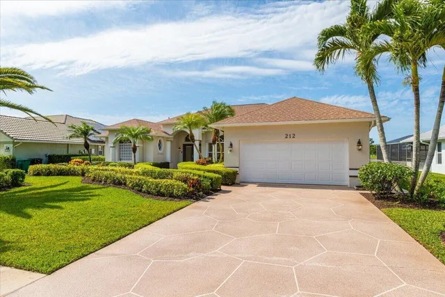a front view of a house with a garden and yard