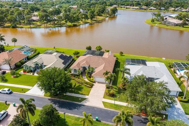 an aerial view of residential houses with outdoor space and lake view