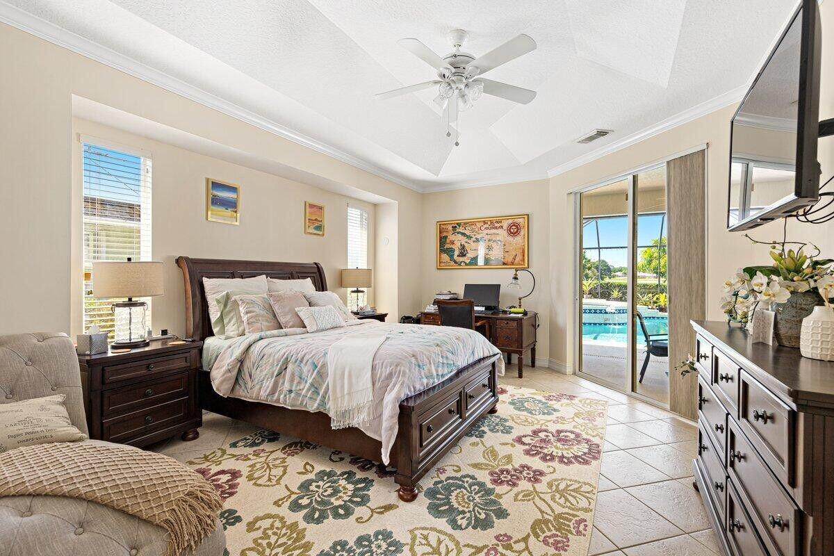 212 Southwest Whitewood Drive Port St. Lucie, FL 34953 - Photo 7 of 26 a bedroom with a large bed and a tv