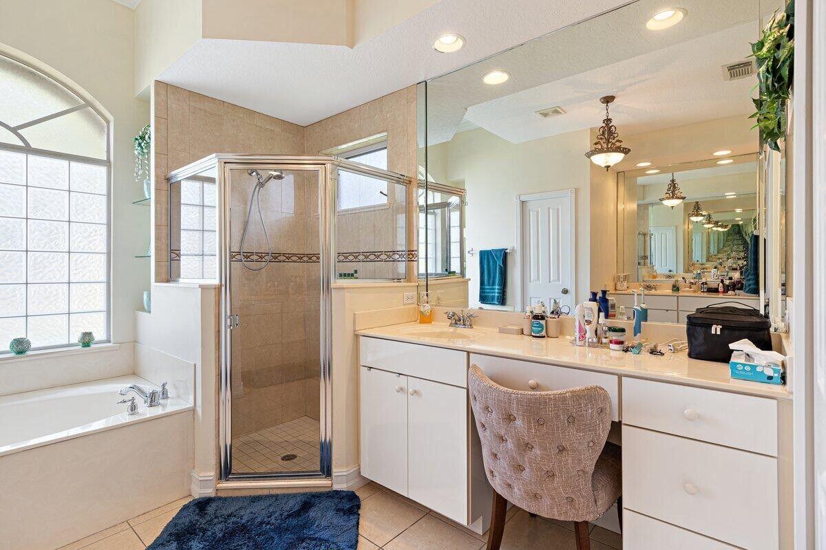 212 Southwest Whitewood Drive Port St. Lucie, FL 34953 - Photo 9 of 26 a bathroom with a double vanity sink a mirror a bathtub and next to a window