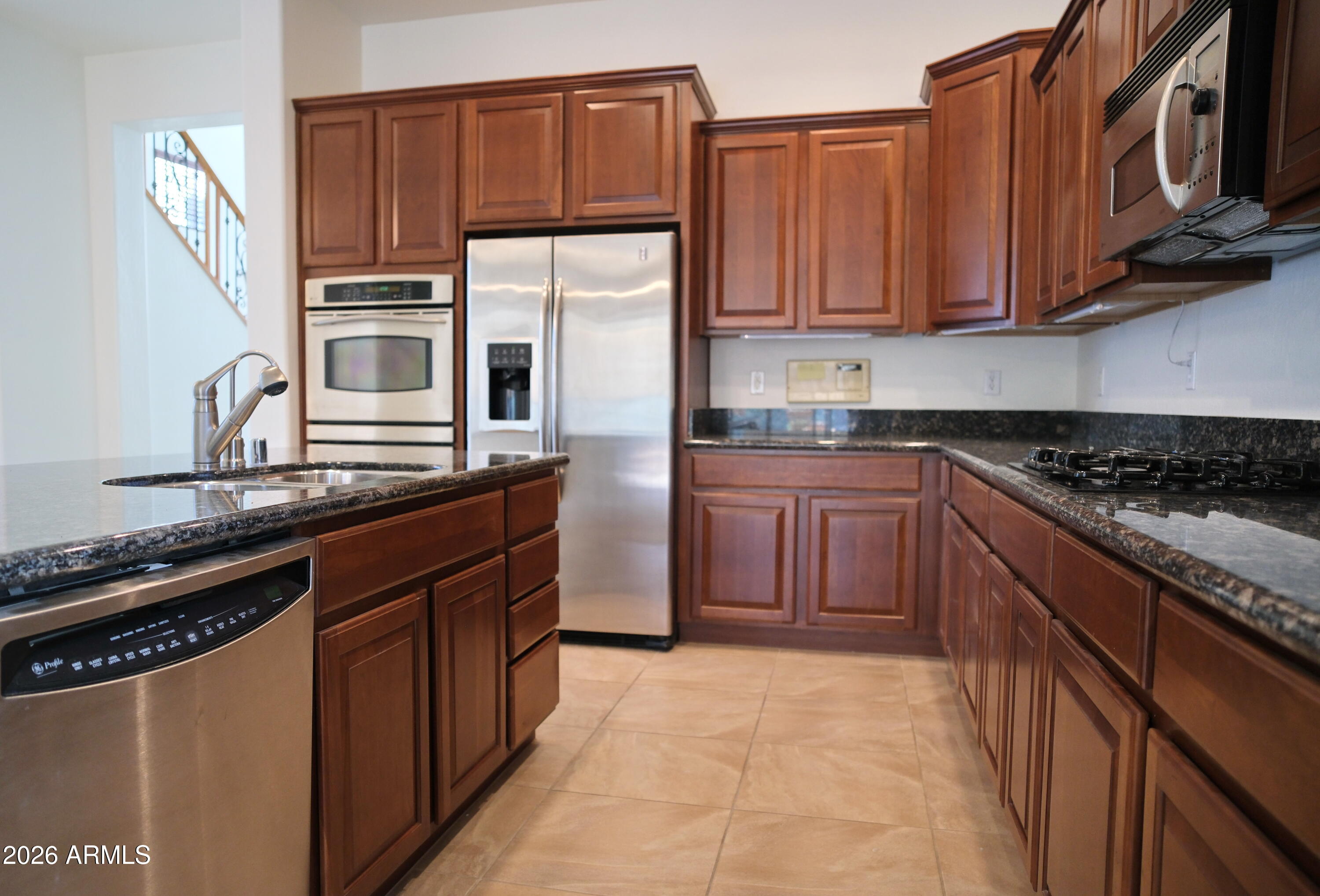 8367 West Briles Road Peoria, AZ 85383 - Photo 12 of 30 a kitchen with stainless steel appliances granite countertop a stove a sink dishwasher and a refrigerator