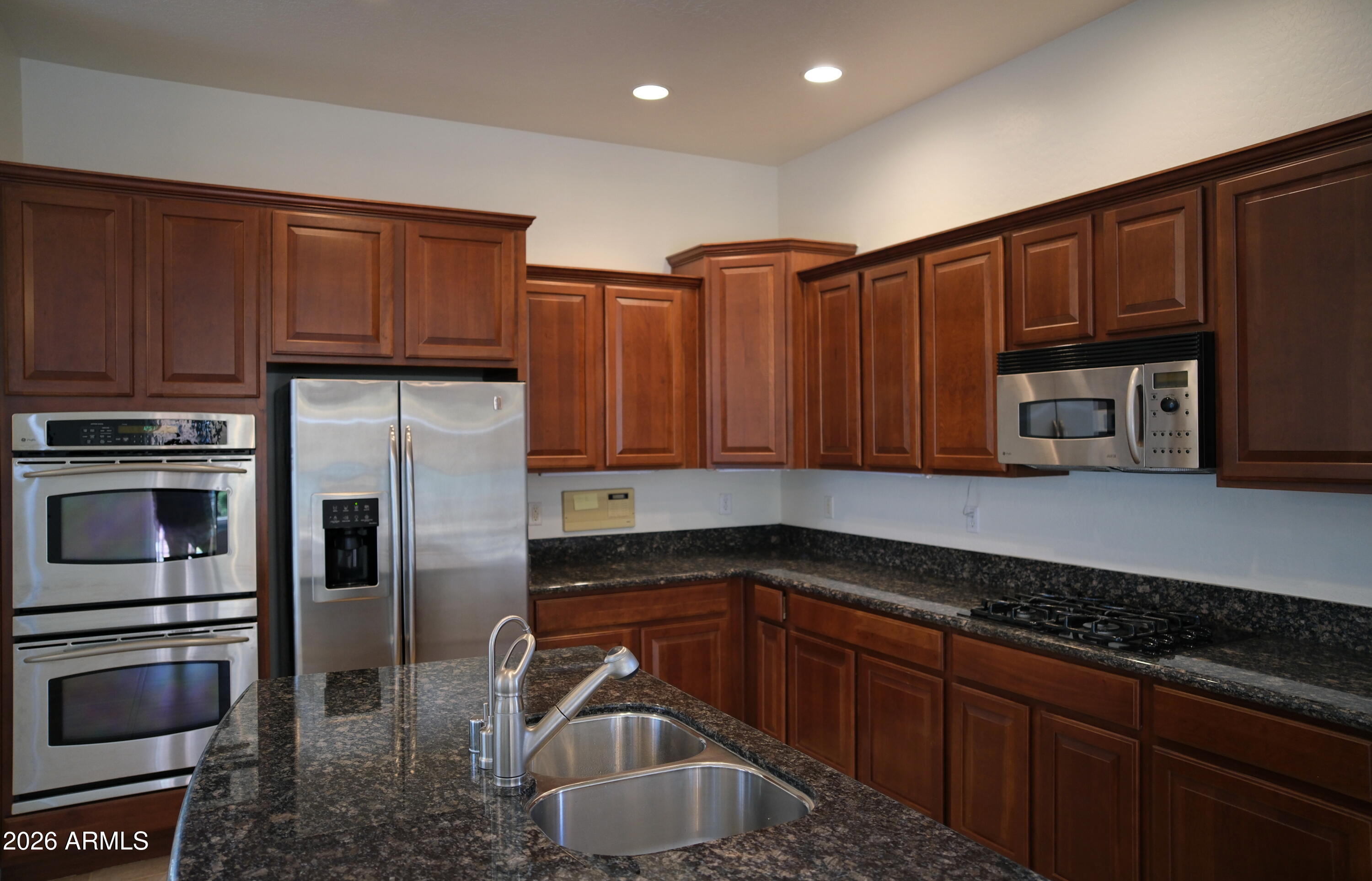 8367 West Briles Road Peoria, AZ 85383 - Photo 13 of 30 a kitchen with kitchen island granite countertop a sink and stainless steel appliances