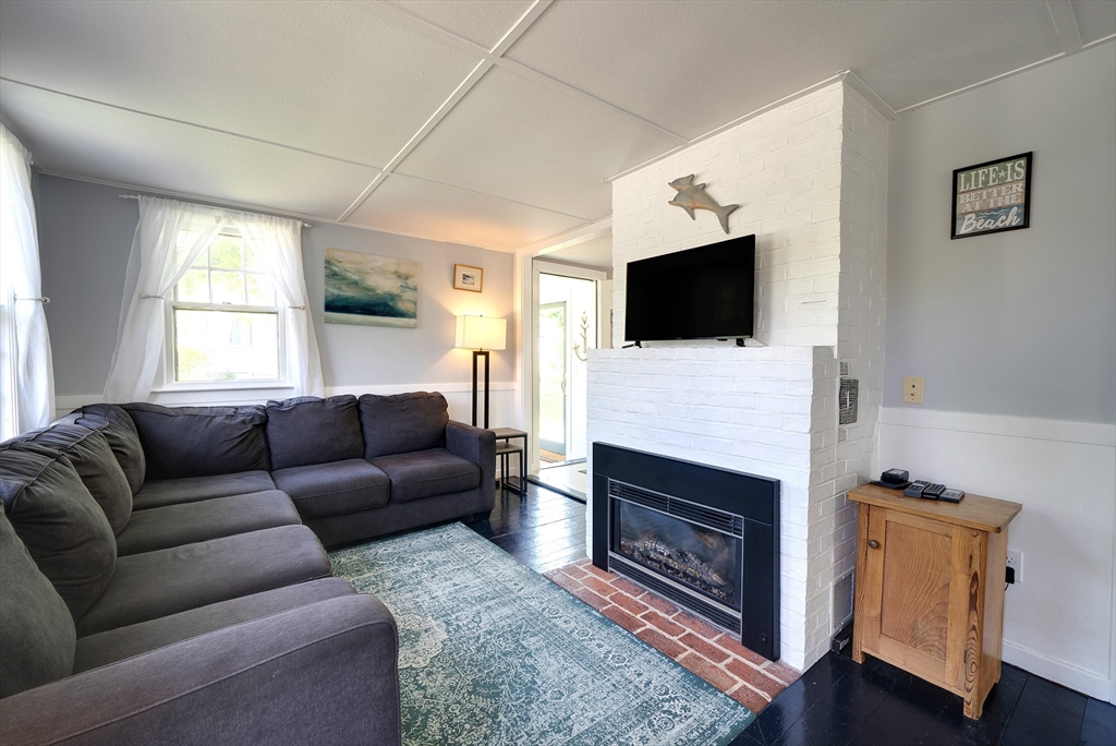 18 Smith Road Rockport, MA 01966 - Photo 9 of 28 a living room with furniture a flat screen tv and a fireplace