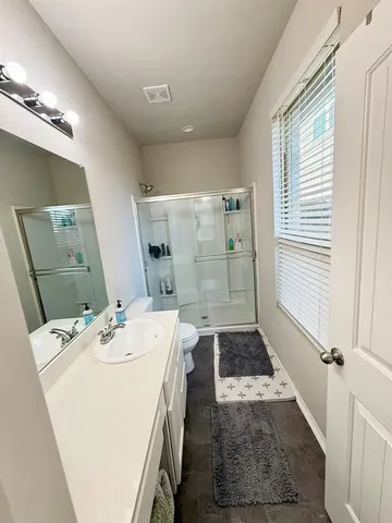 a bathroom with a sink a toilet and shower