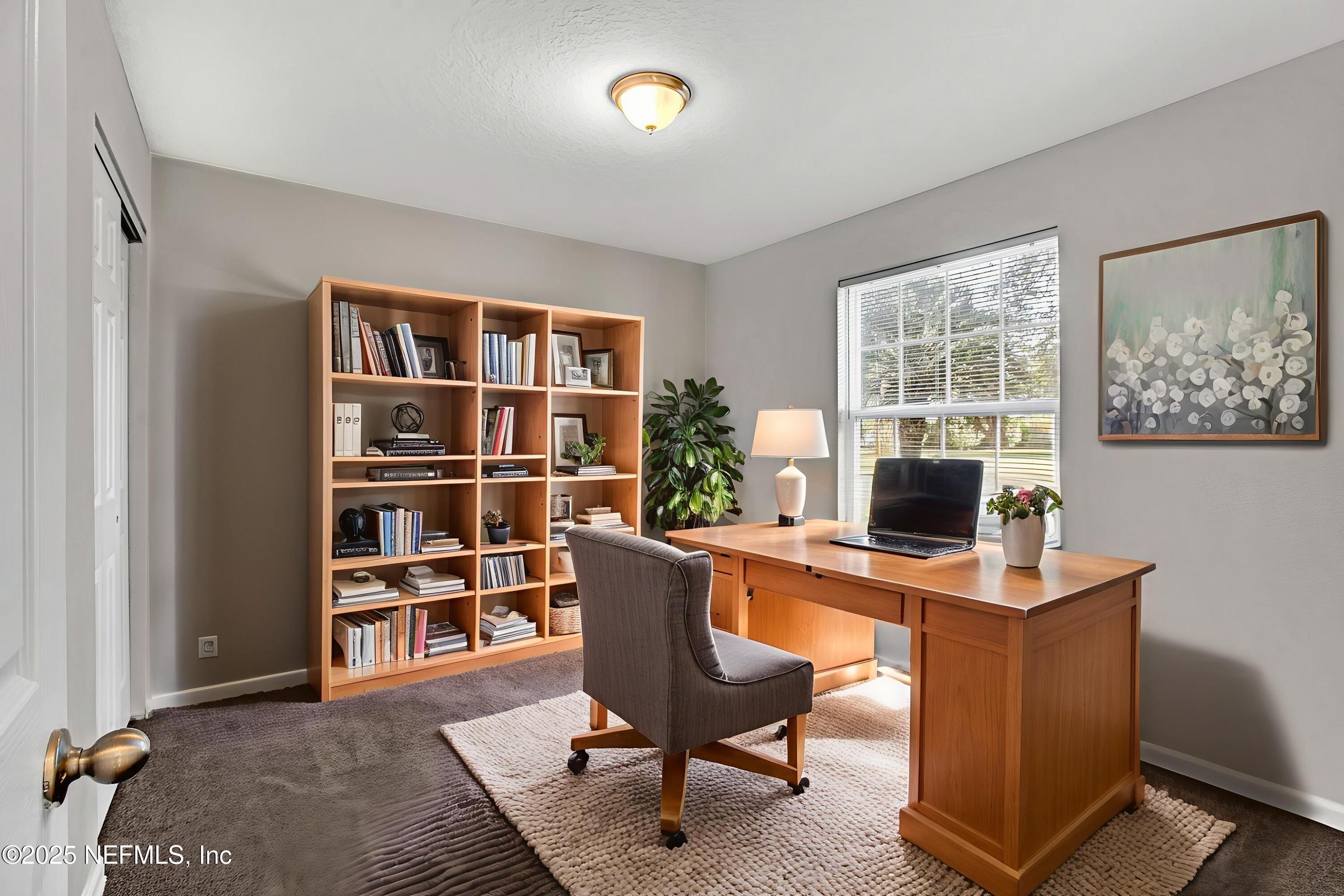 10632 Tulsa Road Jacksonville, FL 32218 - Photo 15 of 25 a view of a workspace with furniture and a bookshelf