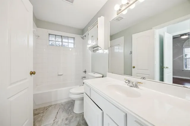 a bathroom with a sink a toilet and a large mirror