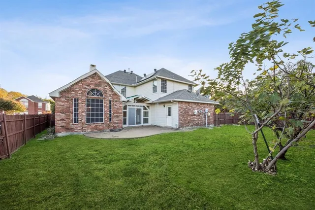 a view of a yard in front of a house with large tree