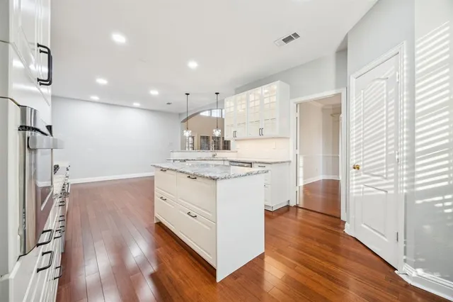 a kitchen with kitchen island white cabinets and stainless steel appliances