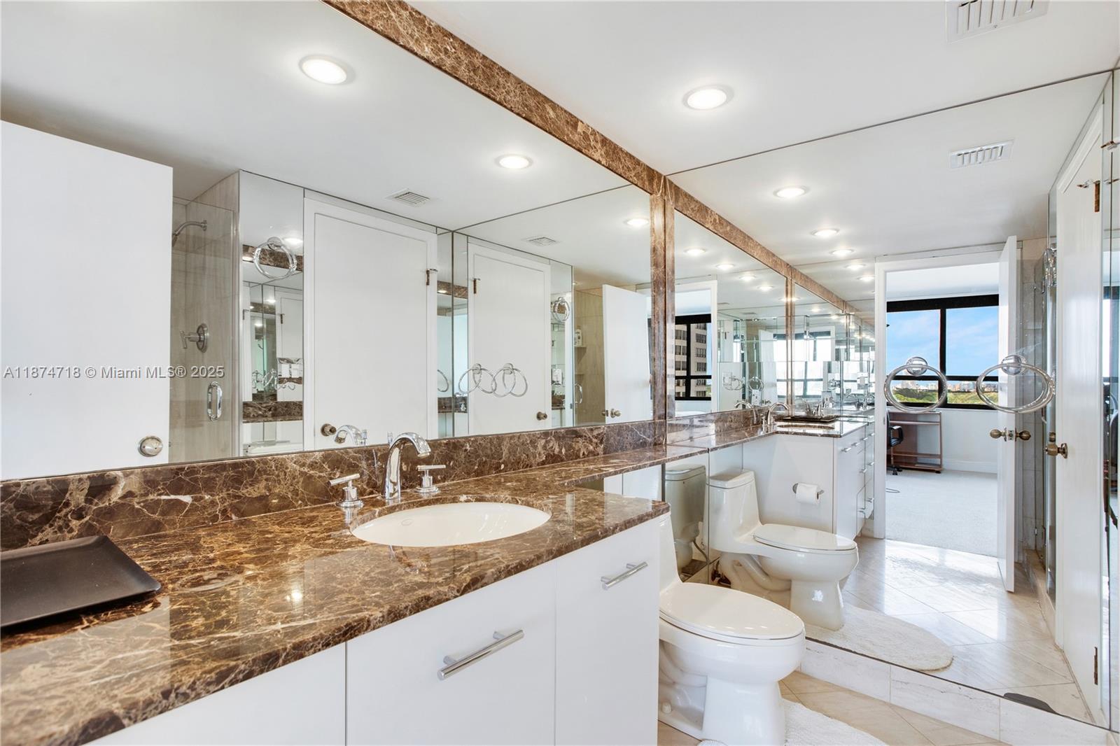 3 Grove Isle Drive, Unit C1108 Miami, FL 33133 - Photo 16 of 30 a bathroom with a granite countertop sink mirror and toilet