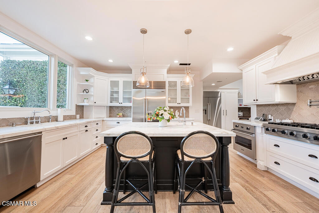 508 West Stafford Road Thousand Oaks, CA 91361 - Photo 14 of 35 a kitchen with stainless steel appliances granite countertop a table chairs stove and white cabinets