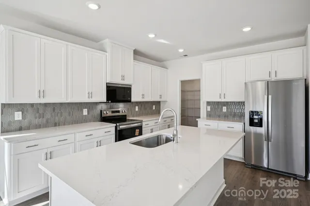 a kitchen with white cabinets and stainless steel appliances
