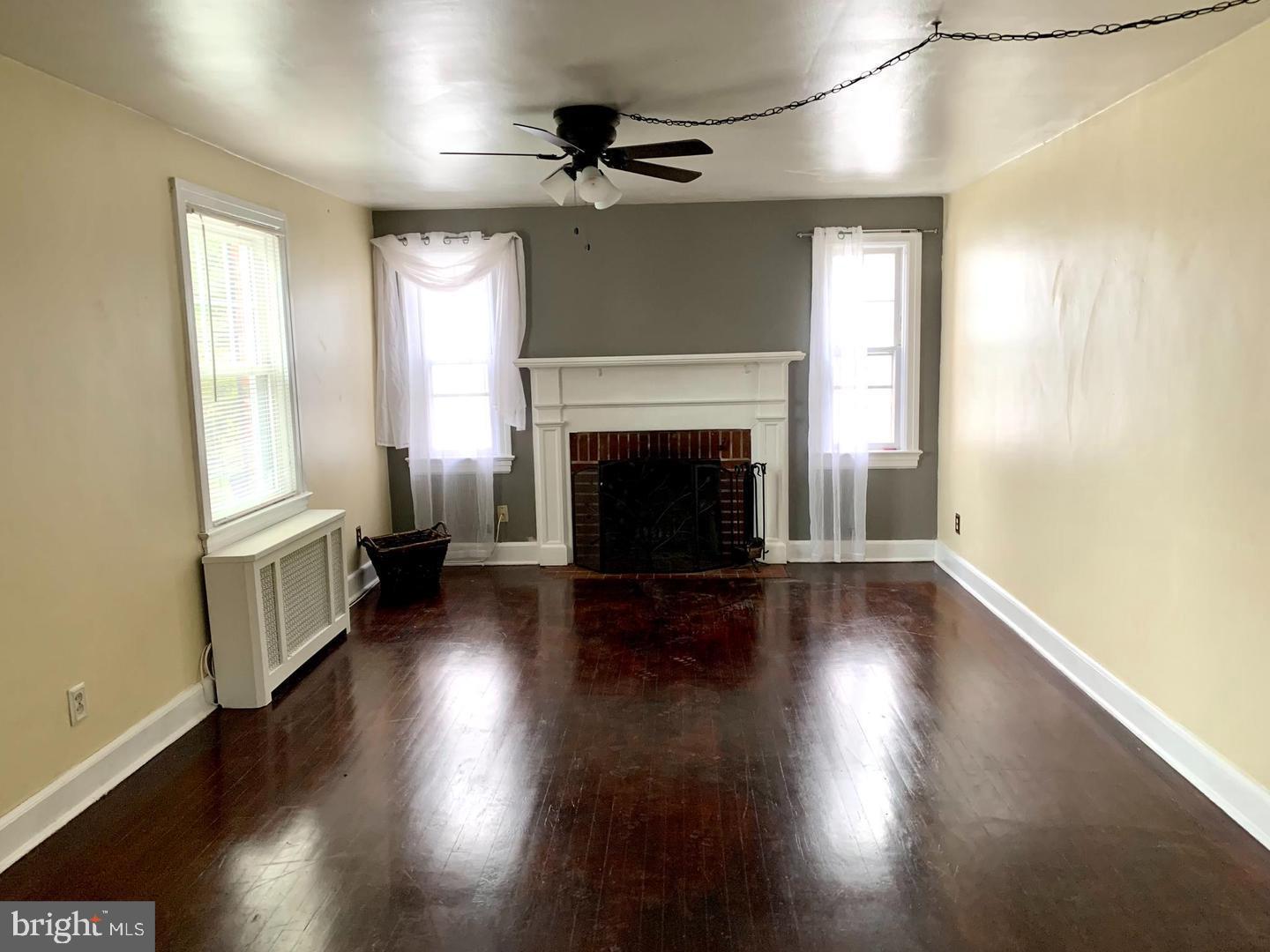 30 Upper Ferry Road Ewing, NJ 08628 - Photo 2 of 12 an empty room with wooden floor fireplace and windows