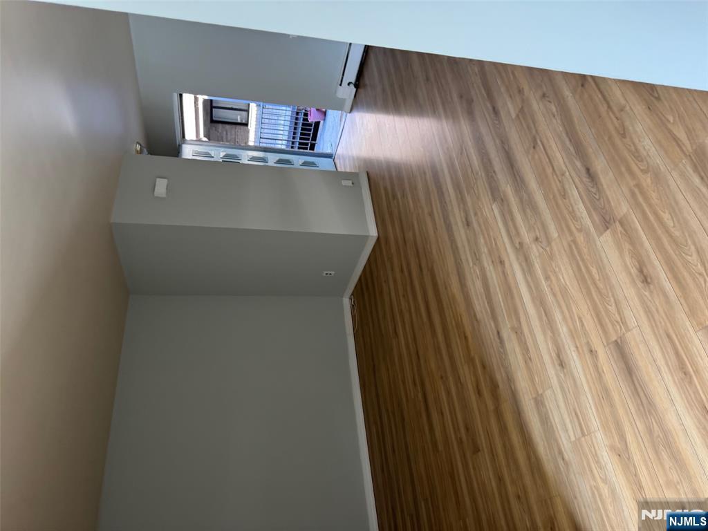 340 Hudson Street, Unit 44 Hackensack, NJ 07601 - Photo 5 of 8 a view of an empty room with wooden floor and a window