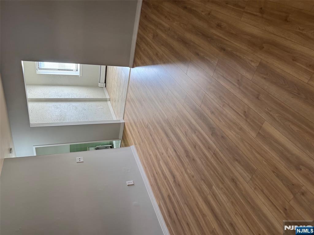 340 Hudson Street, Unit 44 Hackensack, NJ 07601 - Photo 7 of 8 a view of an empty room with wooden floor and windows