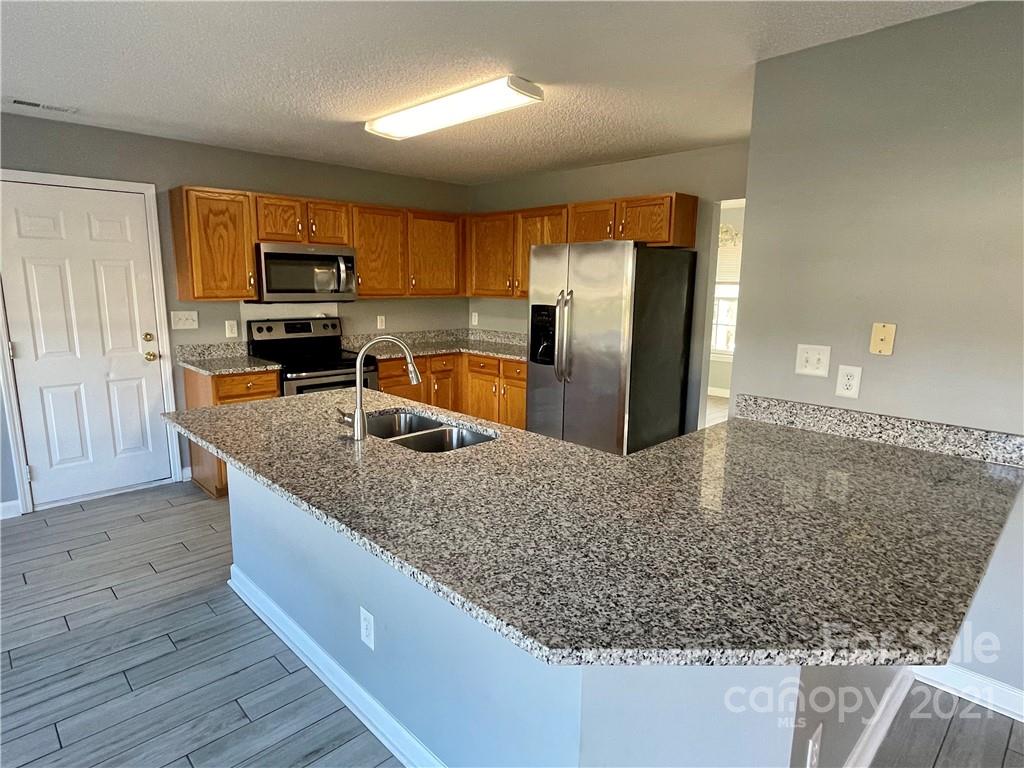 5514 Rogers Road Indian Trail, NC 28079 - Photo 15 of 34 a kitchen with stainless steel appliances granite countertop a sink stove and refrigerator