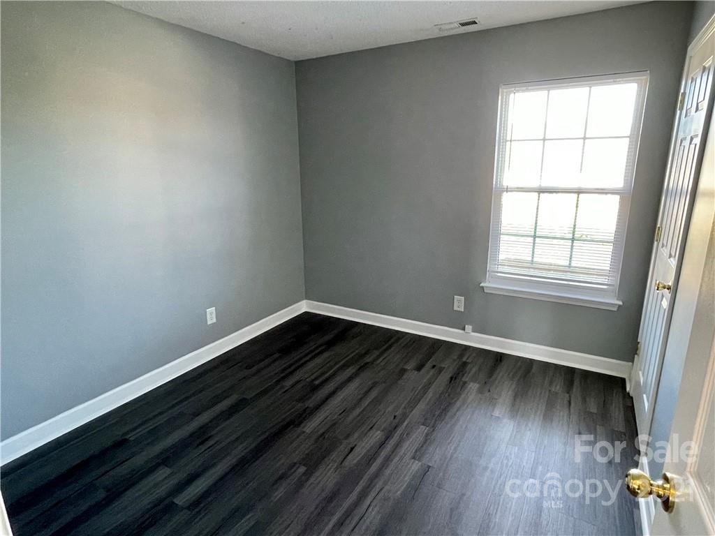 5514 Rogers Road Indian Trail, NC 28079 - Photo 17 of 34 an empty room with wooden floor and windows