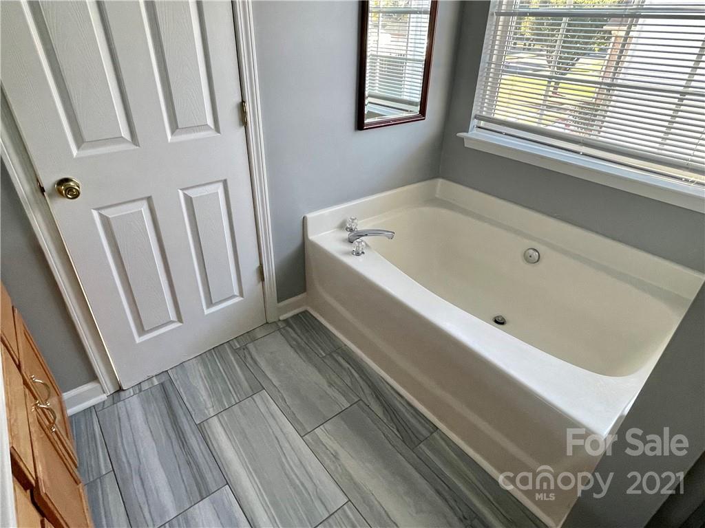 5514 Rogers Road Indian Trail, NC 28079 - Photo 22 of 34 a bathroom with a bathtub and a window