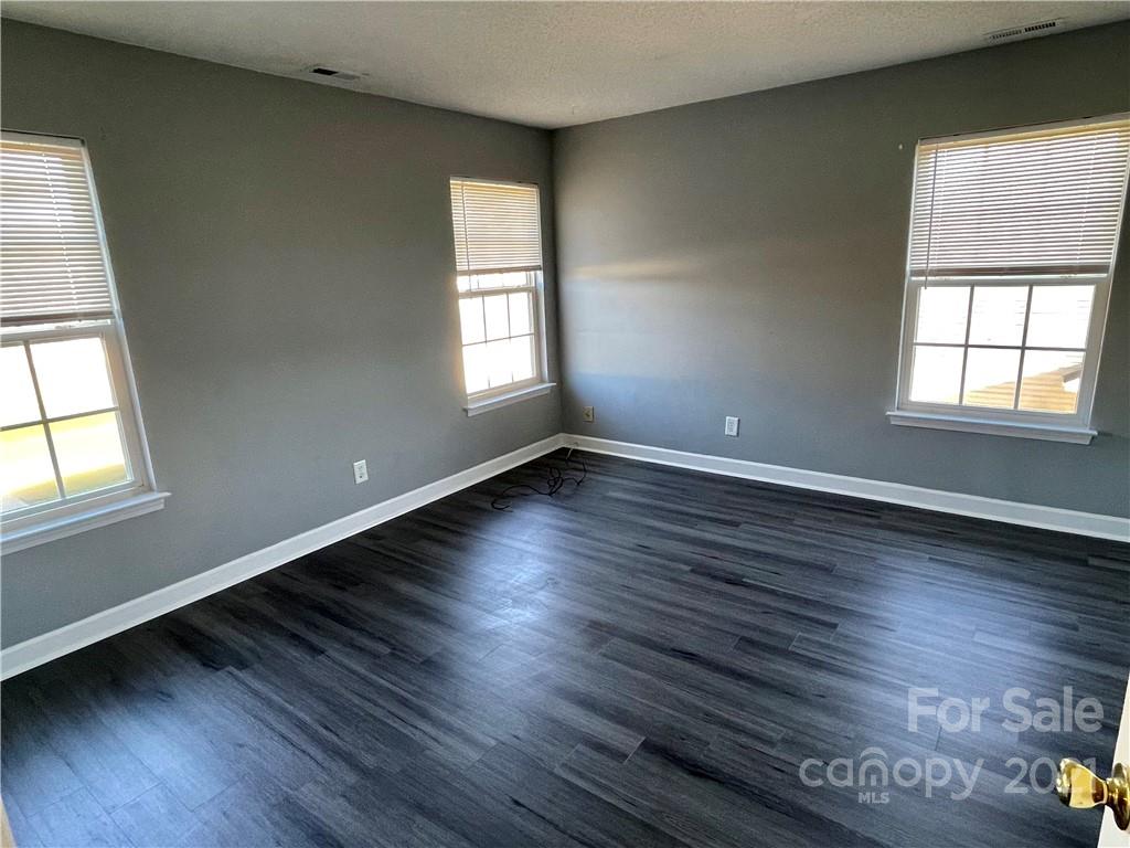 5514 Rogers Road Indian Trail, NC 28079 - Photo 29 of 34 an empty room with wooden floor and windows