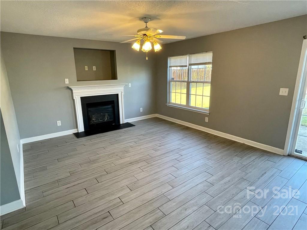 5514 Rogers Road Indian Trail, NC 28079 - Photo 8 of 34 a view of empty room with fireplace and wooden floor