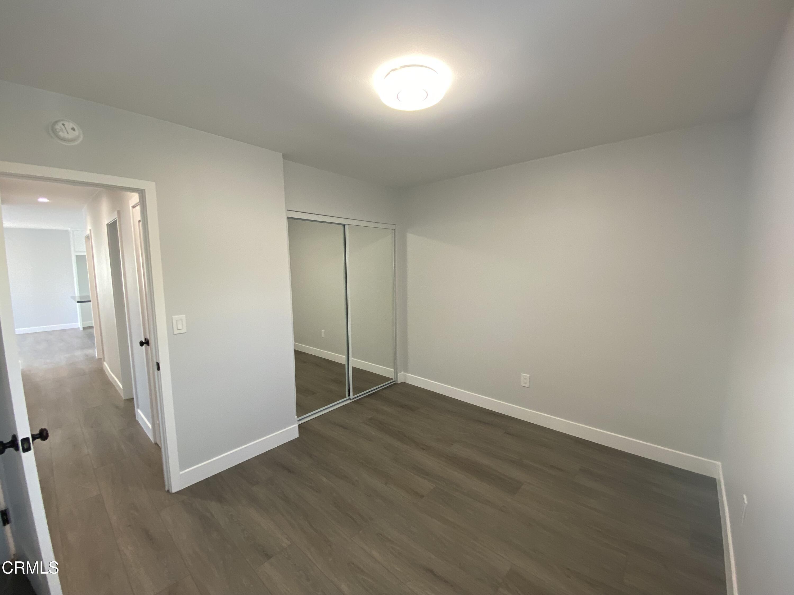 4931 Refsing Place Oxnard, CA 93033 - Photo 14 of 16 an empty room with wooden floor and windows