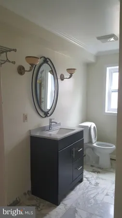 a bathroom with a toilet a sink and mirror