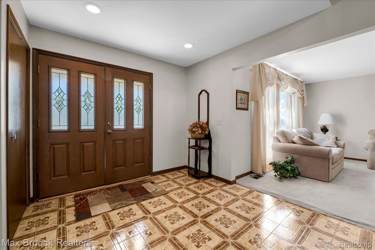 217 Stonetree Circle Rochester, MI 48309 - Photo 3 of 44 Double entry doors with decorative glass panels introduce a foyer featuring patterned floor tiles and recessed lighting