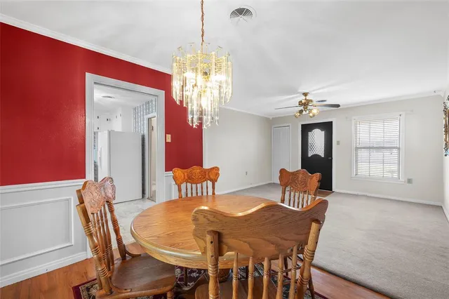 a view of a dining room with furniture wooden floor and chandelier