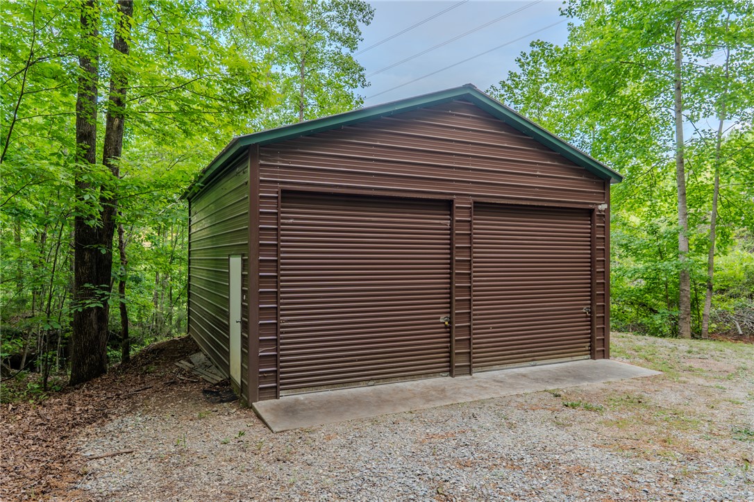 102 State Rd S-39-143 Sunset, SC 29685 - Photo 46 of 47 This practical outbuilding offers versatile storage or workshop space amidst lush greenery.