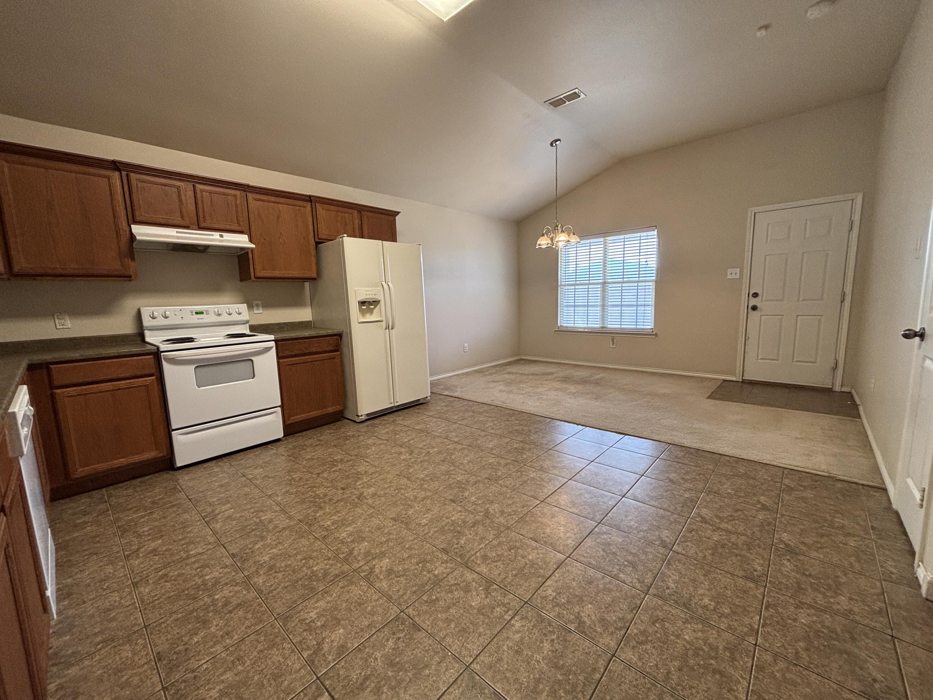 6515 92nd Street Lubbock, TX 79424 - Photo 3 of 9 a kitchen with stainless steel appliances granite countertop a stove a sink and a refrigerator