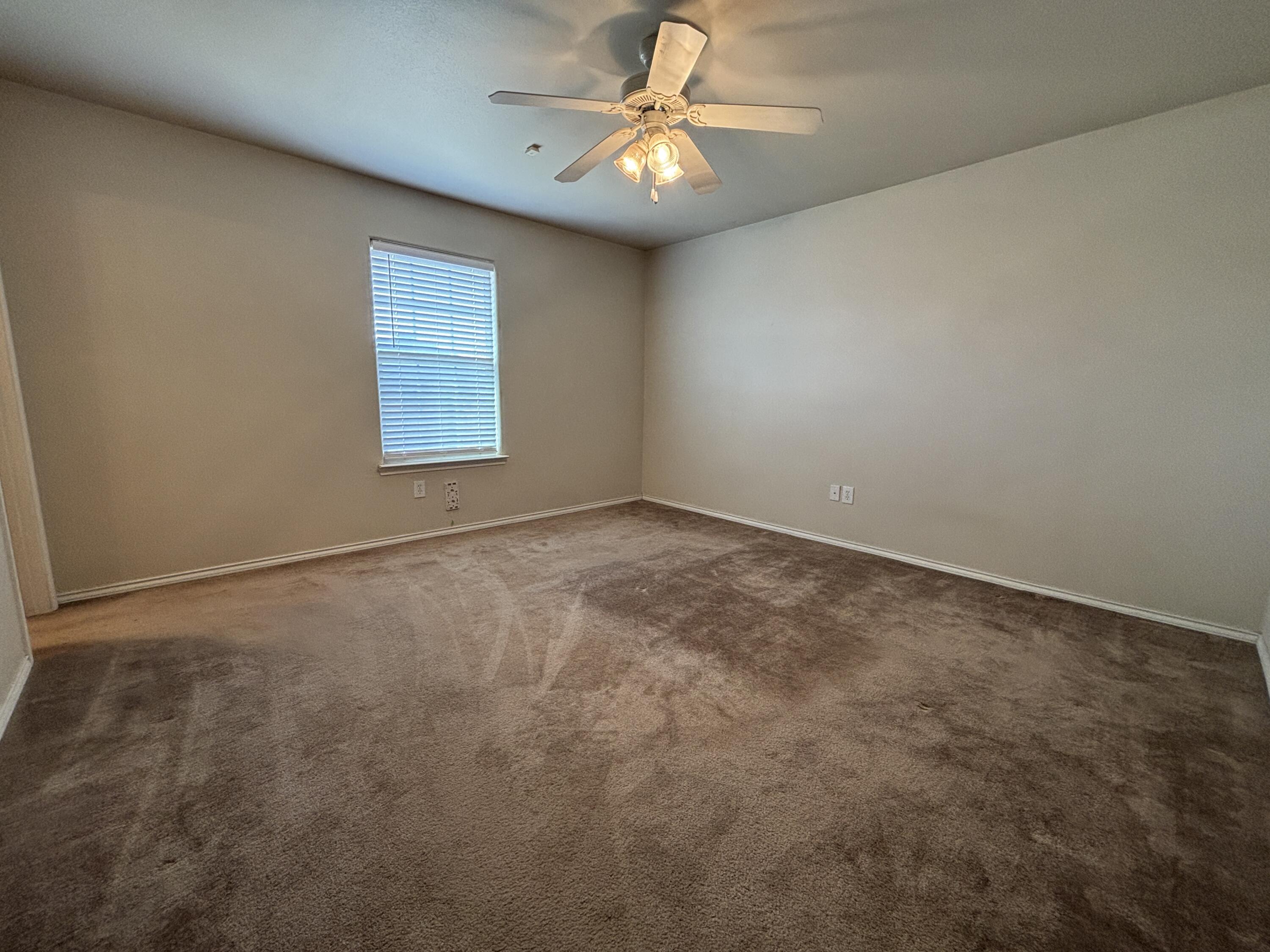6515 92nd Street Lubbock, TX 79424 - Photo 5 of 9 an empty room with windows and fan