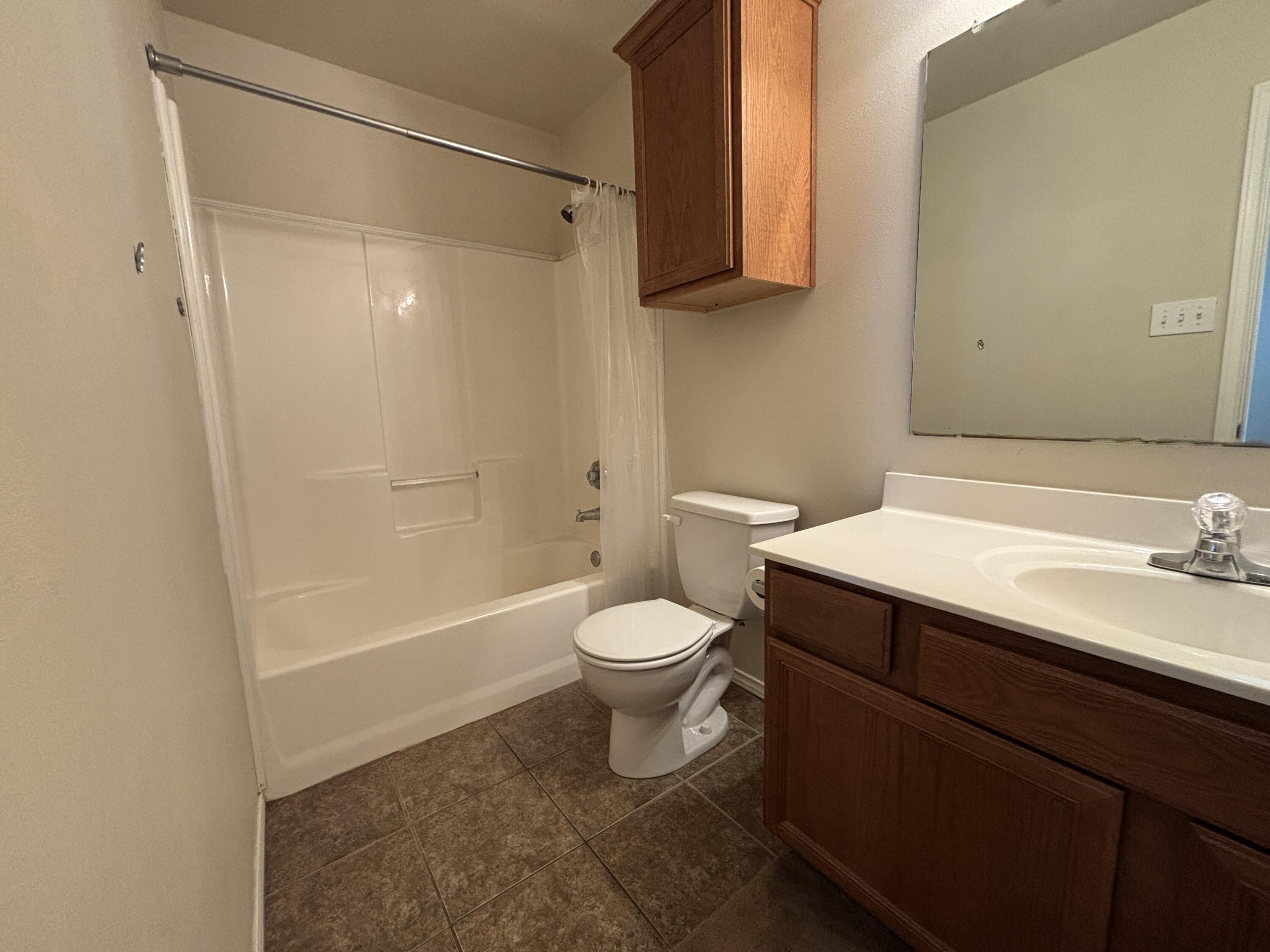 6515 92nd Street Lubbock, TX 79424 - Photo 6 of 9 a bathroom with a sink a toilet and shower
