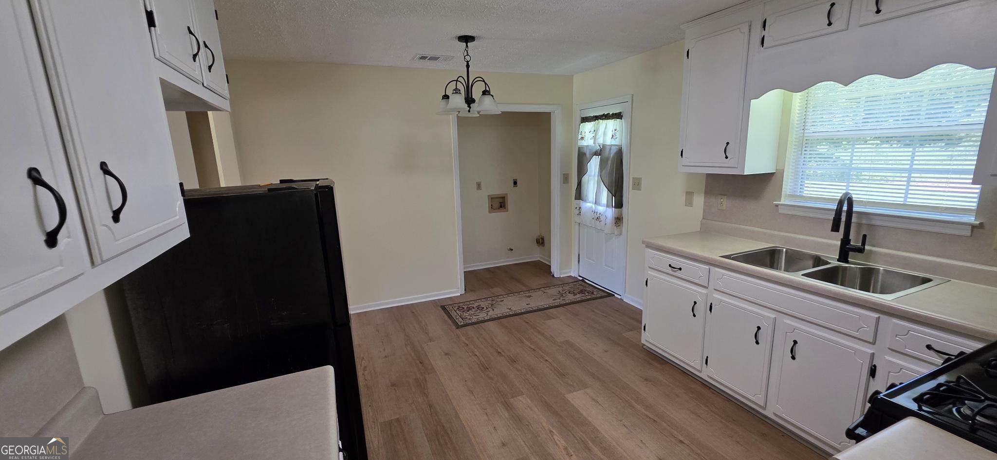 657 Tom McKinley Road Thomaston, GA 30286 - Photo 18 of 32 a kitchen with granite countertop a refrigerator and a sink