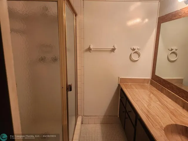 a bathroom with a granite countertop sink and shower