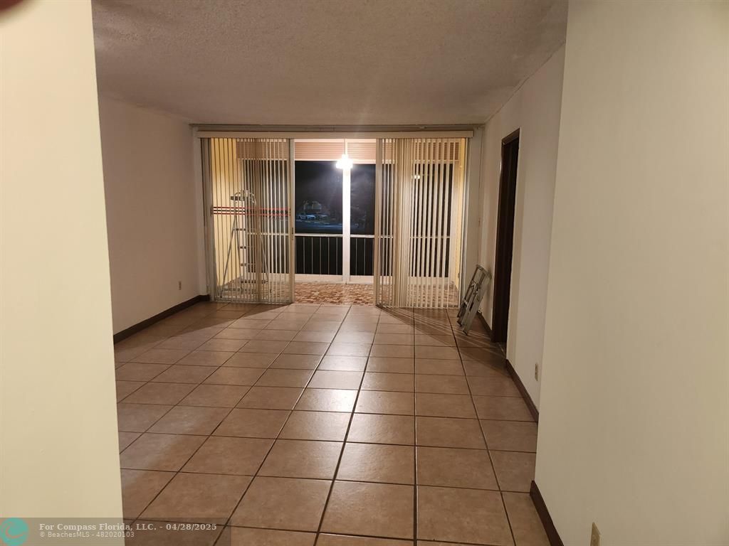 5830 Northwest 64th Avenue, Unit 209 Fort Lauderdale, FL 33319 - Photo 7 of 9 a view of a livingroom with an empty space and a window