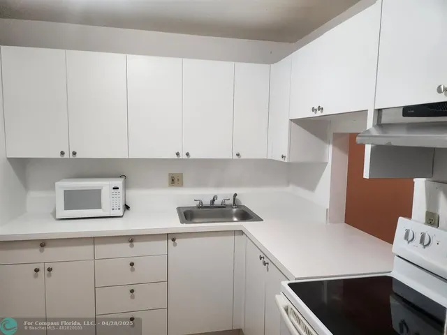 a kitchen with stainless steel appliances white cabinets and a refrigerator