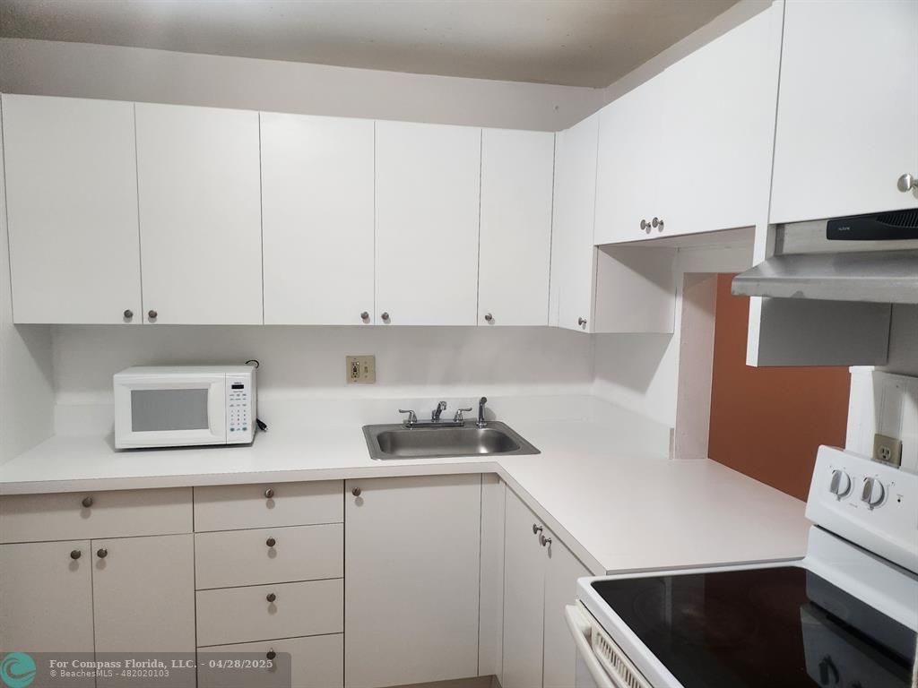 5830 Northwest 64th Avenue, Unit 209 Fort Lauderdale, FL 33319 - Photo 8 of 9 a kitchen with cabinets and appliances