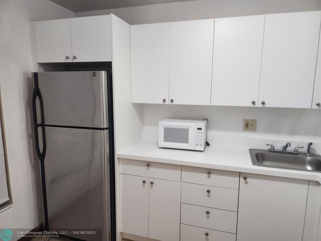 5830 Northwest 64th Avenue, Unit 209 Fort Lauderdale, FL 33319 - Photo 9 of 9 a kitchen with stainless steel appliances white cabinets and a refrigerator