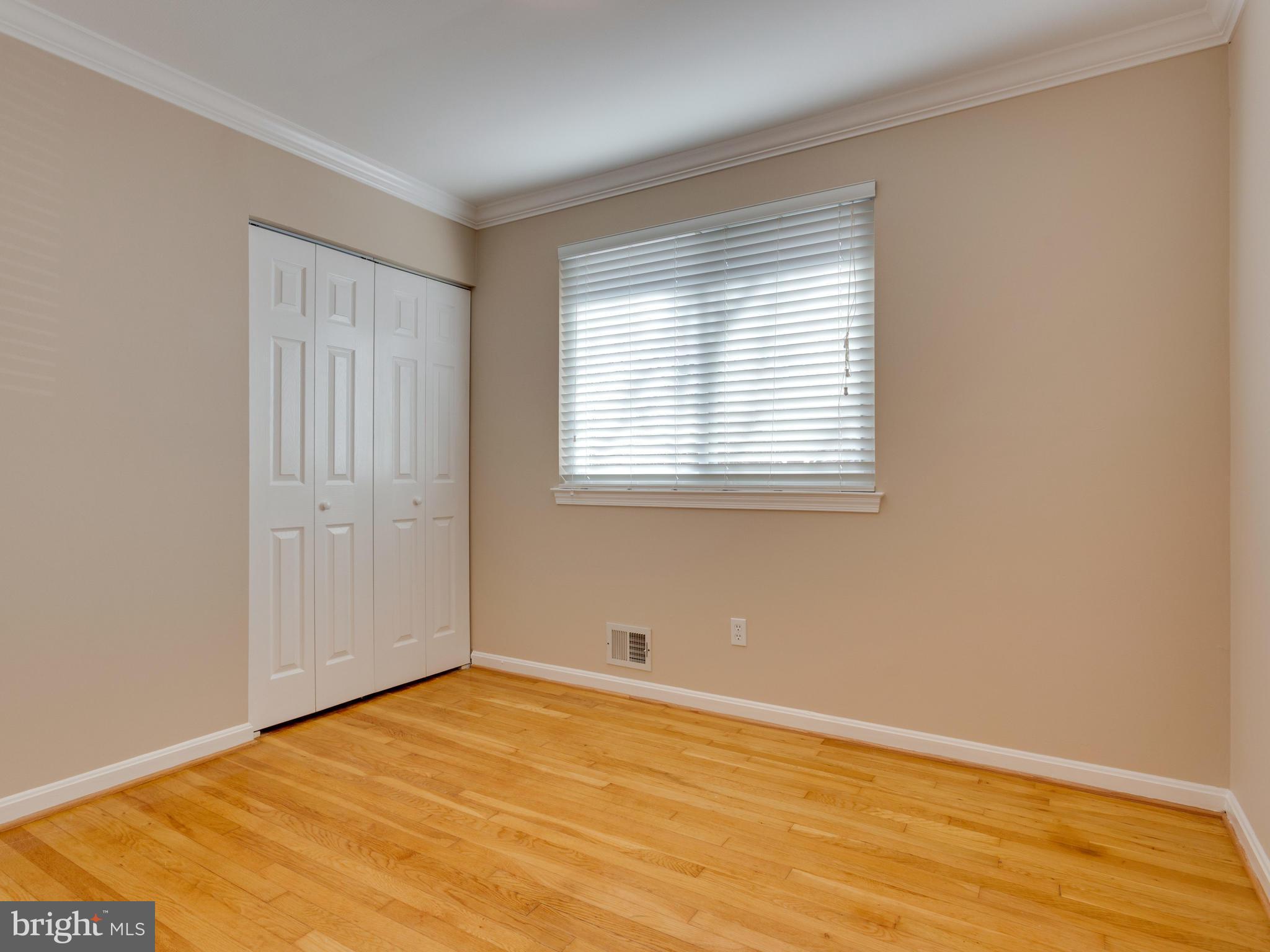 8702 Victoria Road Springfield, VA 22151 - Photo 14 of 27 a view of an empty room with wooden floor and a window